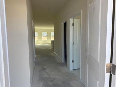 Hallway with unfinished concrete flooring