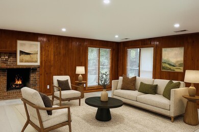 Living area featuring wooden walls, recessed lighting, and a brick fireplace