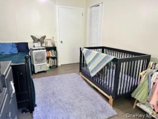 Bedroom featuring a crib and light wood-type flooring