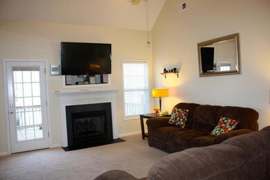 Another view of living room with natural gas log fireplace.