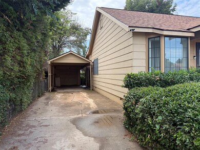View of side of property with a shingled roof, a detached garage, and concrete driveway
