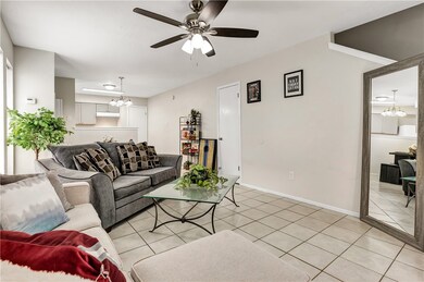 Tiled living room featuring ceiling fan with notab