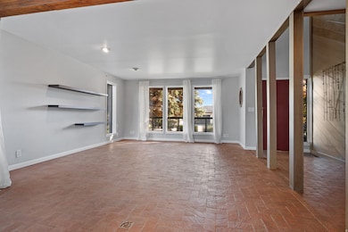 living room featuring brick floors and baseboards