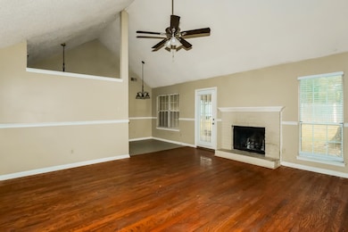 Unfurnished living room featuring high vaulted ceiling, dark wood finished floors, a brick fireplace, and a ceiling fan