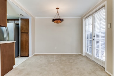 Unfurnished dining area featuring ornamental molding and light carpet