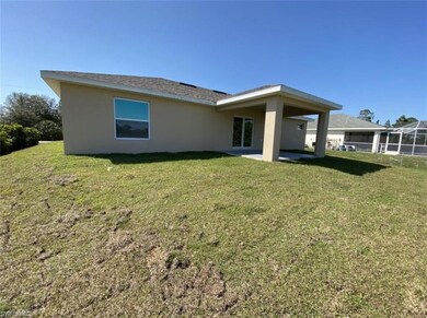 Back of property with stucco siding, a lawn, and a patio
