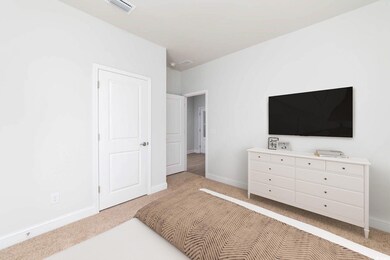 Bedroom with baseboards, light colored carpet, and