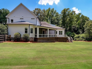 Rear view of property featuring stairs, a deck, and a sunroom