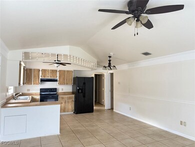 Kitchen featuring a ceiling fan, black appliances, light countertops, lofted ceiling, and light tile patterned flooring