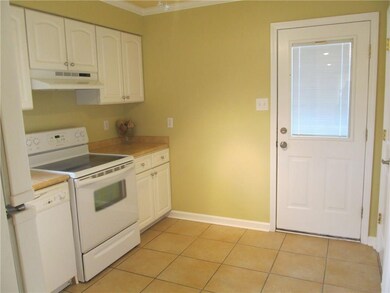 Kitchen has electric stove and door leading out to