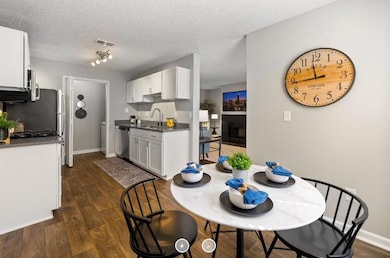 Dining room with dark hardwood / wood-style flooring, a tiled fireplace, rail lighting, sink, and a textured ceiling