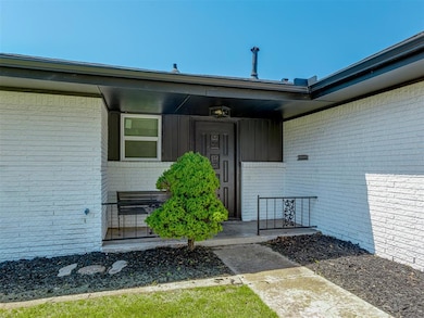 Doorway to property with brick siding and covered porch
