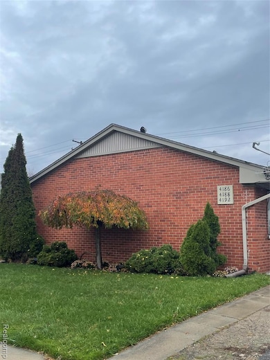 View of home's exterior with a lawn and brick siding