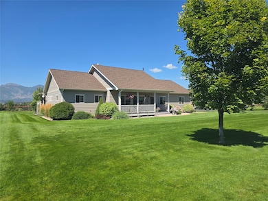 Front view of property with a porch, a yard, roof with shingles, and a mountain view