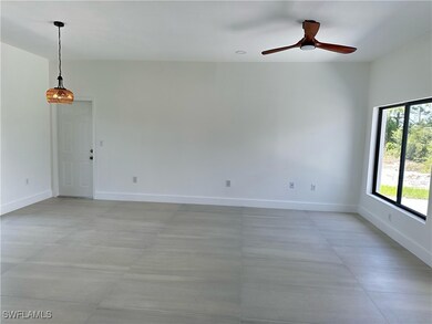 Empty room featuring ceiling fan and baseboards