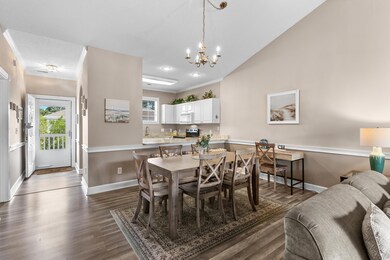 Dining space featuring crown molding, a chandelier, and dark wood-style flooring