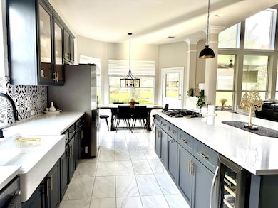 Kitchen with wine cooler, gas stovetop, light mar