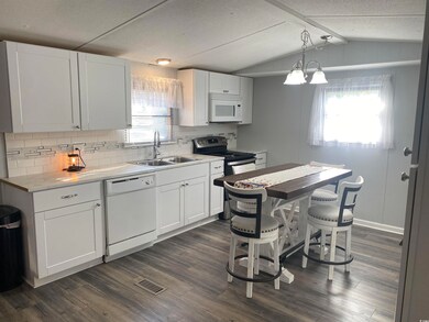Kitchen featuring white appliances, decorative bac
