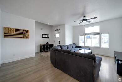 Living area featuring light wood-type flooring, a ceiling fan, and recessed lighting