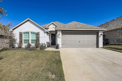 View of front of home with brick siding, concrete driveway, a front yard, and a garage