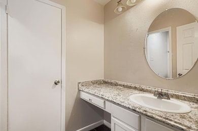 Bathroom with vanity and a textured wall
