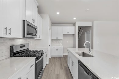 Kitchen with white cabinets, light wood-style floo