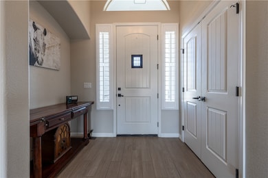 Entryway with wood finished floors, baseboards, an