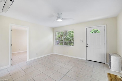 Foyer entrance with light tile patterned floors and a ceiling fan