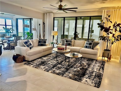 Living room with ceiling fan, crown molding, and light tile patterned flooring