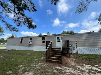 Rear view of property with cooling unit and a yard