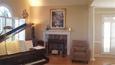 Sitting room featuring a tiled fireplace, light ha