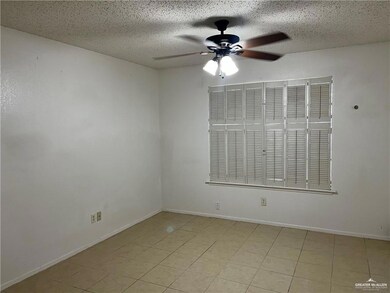 Unfurnished room with ceiling fan and a textured ceiling
