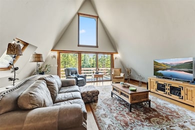 Living room featuring high vaulted ceiling and wood finished floors