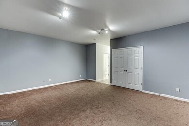 Spare room featuring carpet flooring and baseboards
