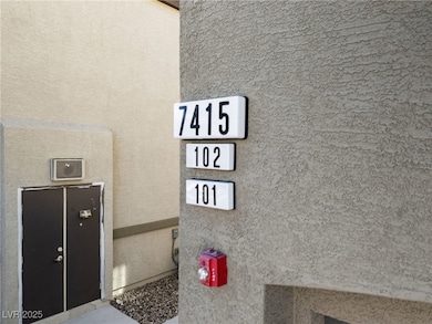 Exterior view of stucco siding and a fire alarm