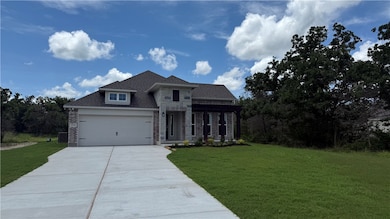 View of front of house with stone siding, concrete