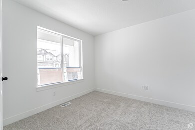 Carpeted spare room featuring baseboards