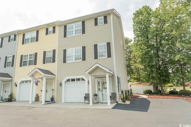 View of property featuring an attached garage and asphalt driveway