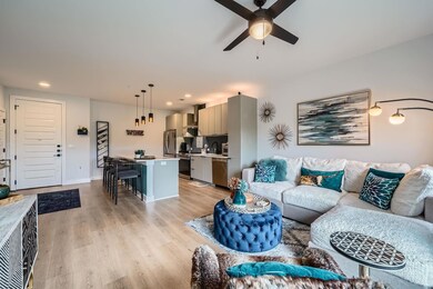 Living area featuring a ceiling fan, light wood-s