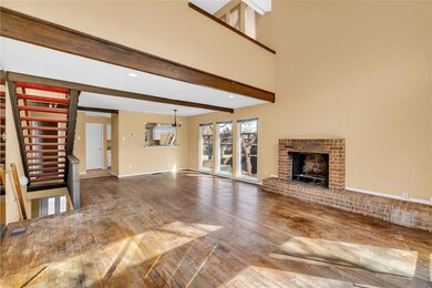 Unfurnished living room with beamed ceiling, a bri