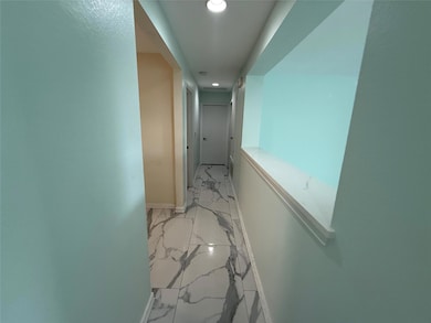 Hall featuring light marble finish flooring, rece