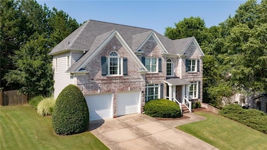 View of front of house featuring driveway, a garage, and brick siding