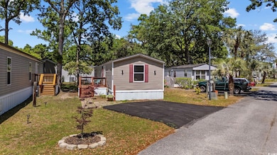 Manufactured / mobile home featuring a front yard and a wooden deck