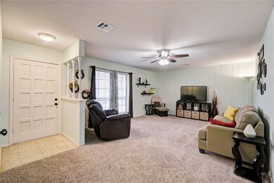 Living room with ceiling fan large front windows.