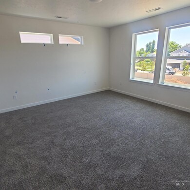 Empty room featuring plenty of natural light and dark colored carpet