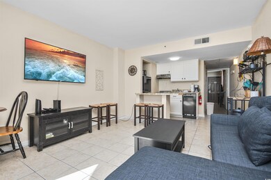Living area featuring light tile patterned floors and attic access