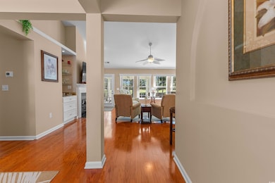 Living room with light wood-type flooring, a fireplace, and ceiling fan