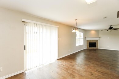 Unfurnished living room featuring hardwood / wood-style flooring, a tile fireplace, and ceiling fan