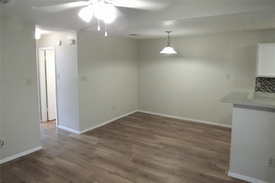 Unfurnished dining area with dark wood-type flooring and ceiling fan