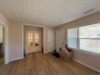 Interior space featuring french doors, a textured 